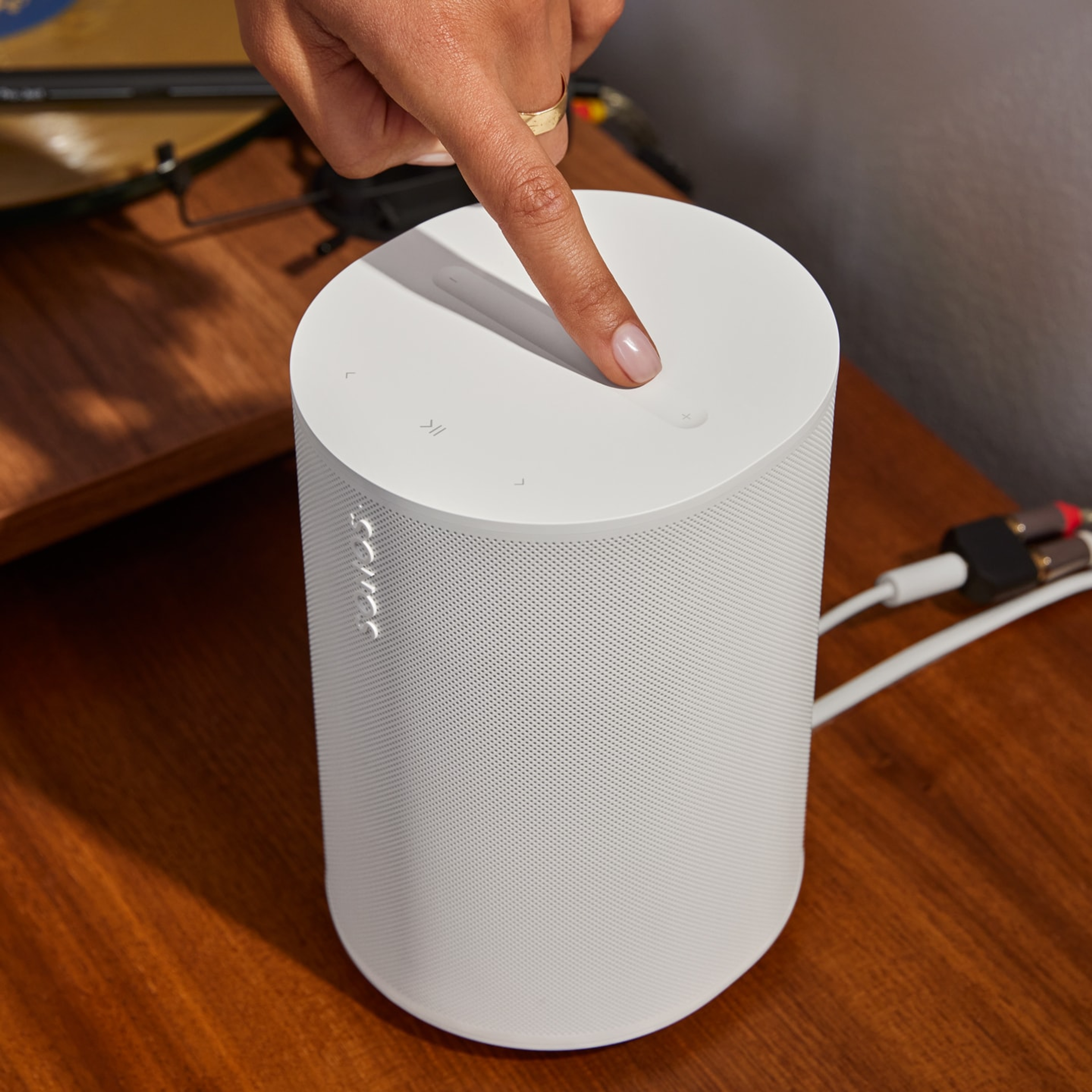 User adjusting music volume with the top touch controls on a white Era 100 SL