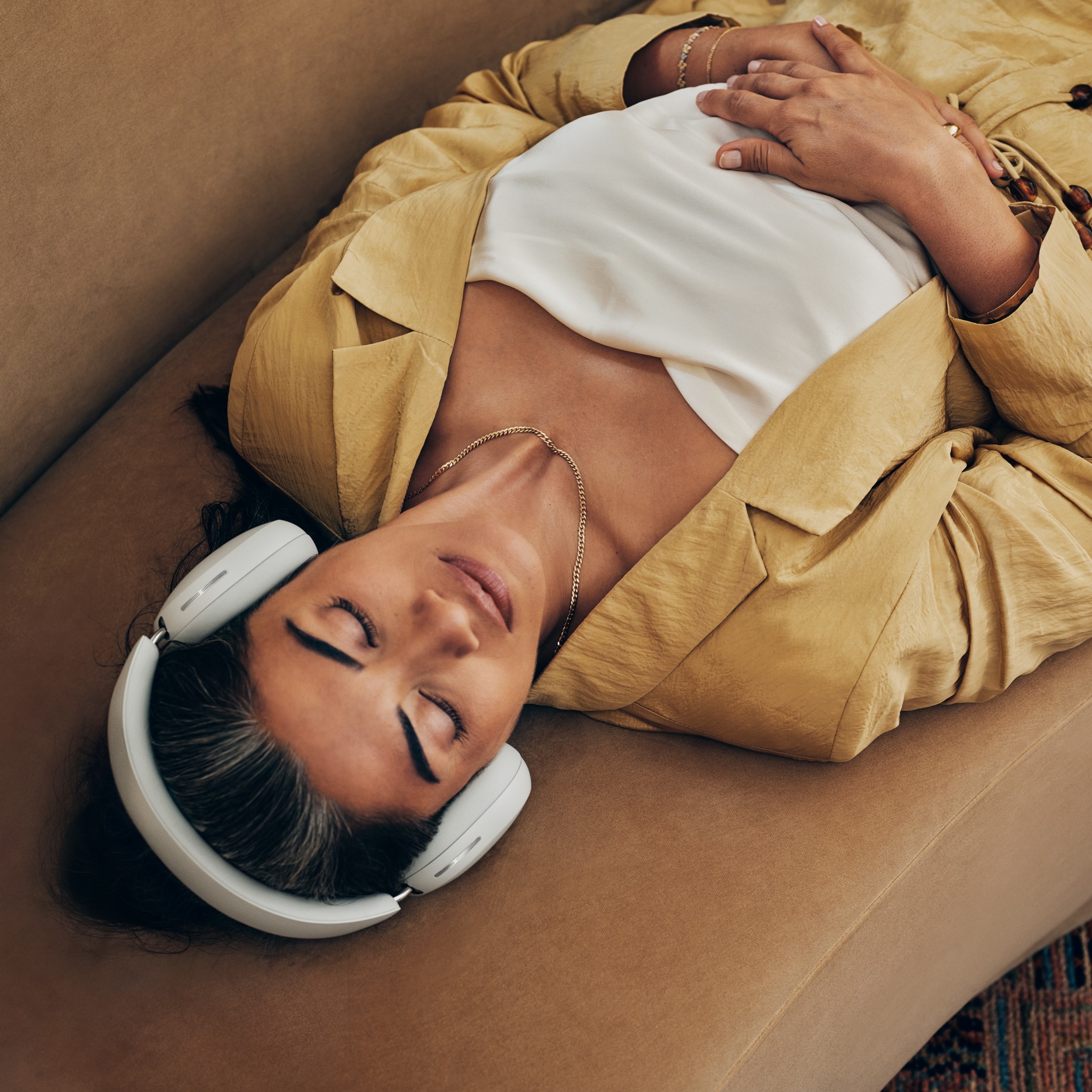 Une personne écoutant de la musique avec un casque audio Sonos Ace blanc