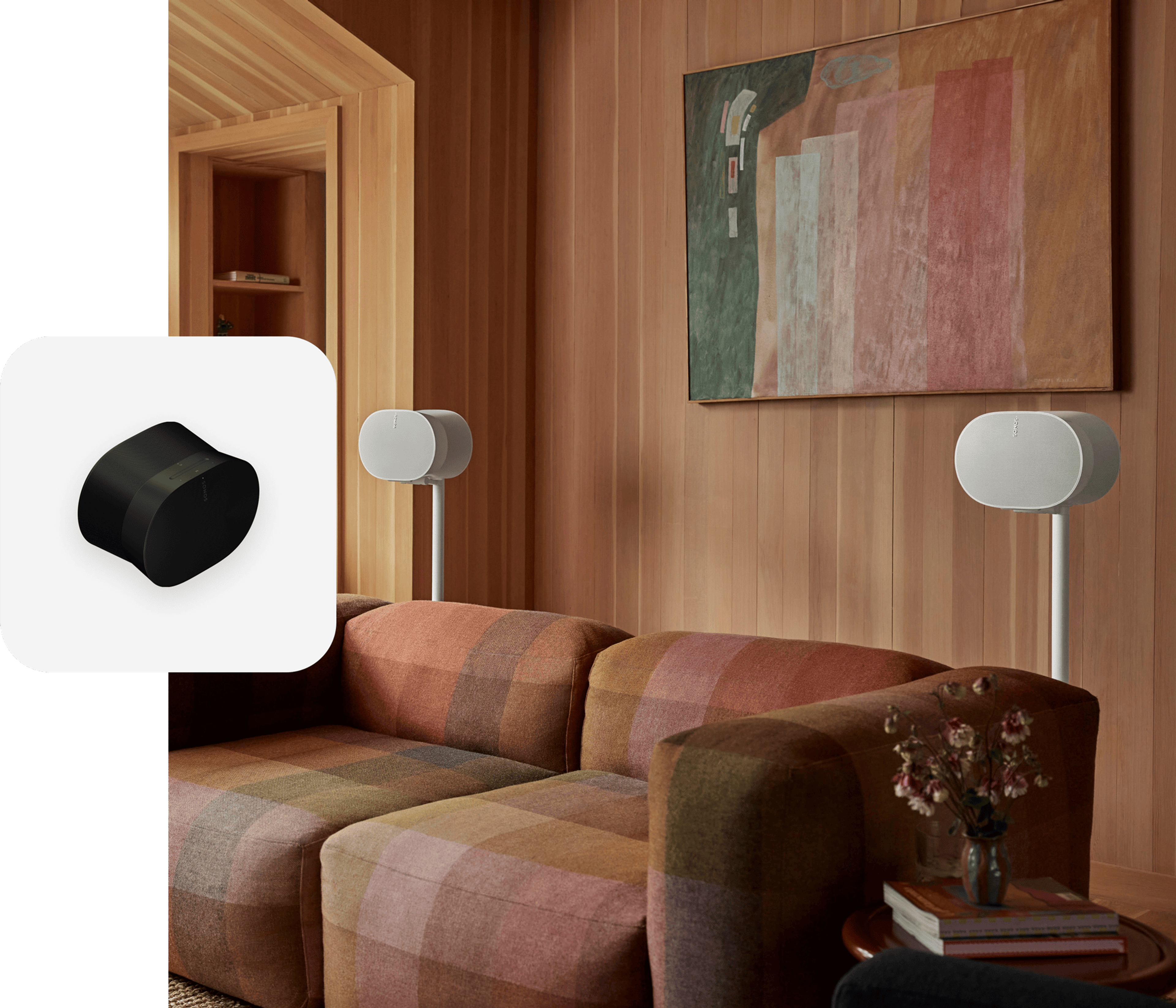 A pair of white Era 300 speakers on stands set up behind a couch for surround sound
