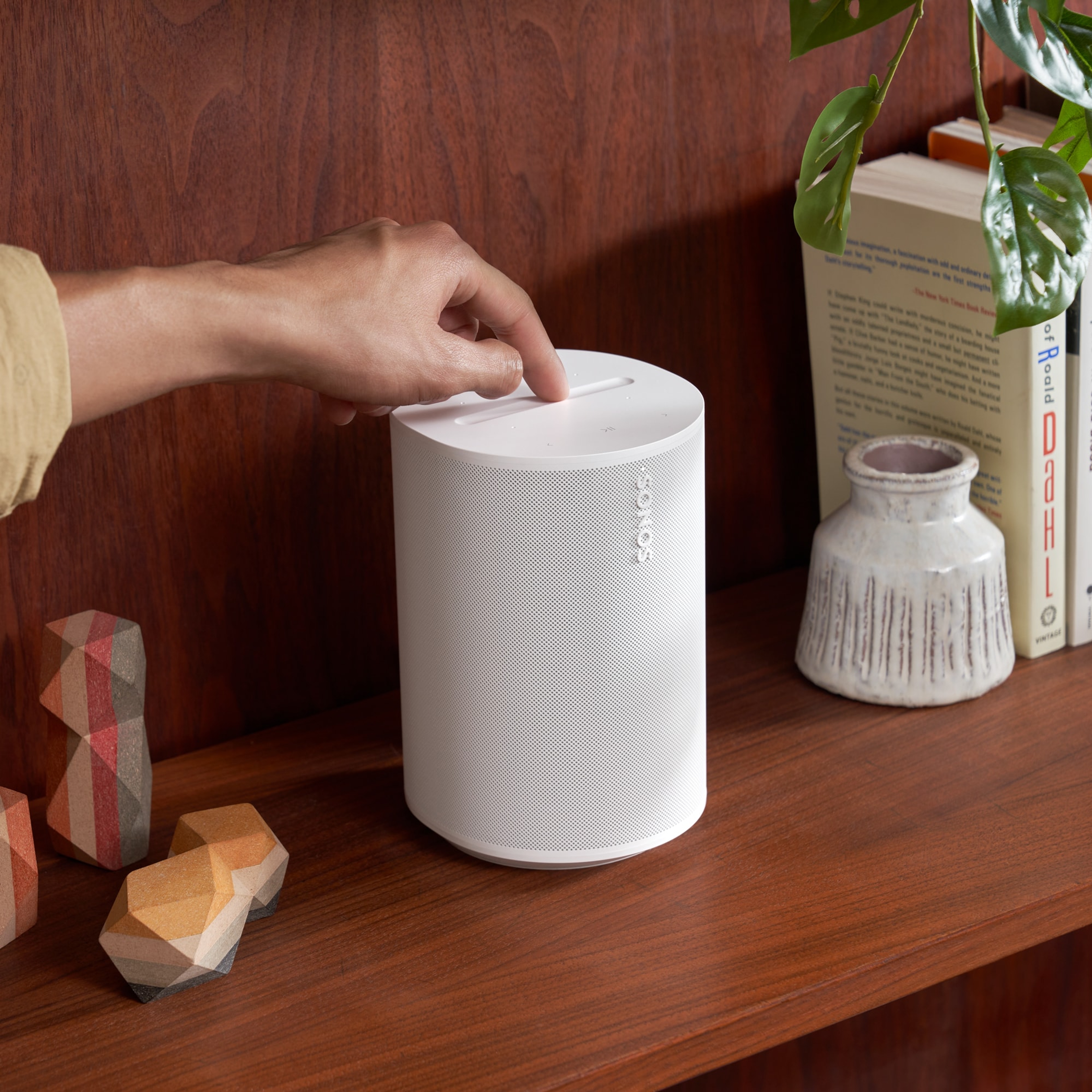Personne utilisant les commandes sur le dessus d’une enceinte Era 100 blanche
