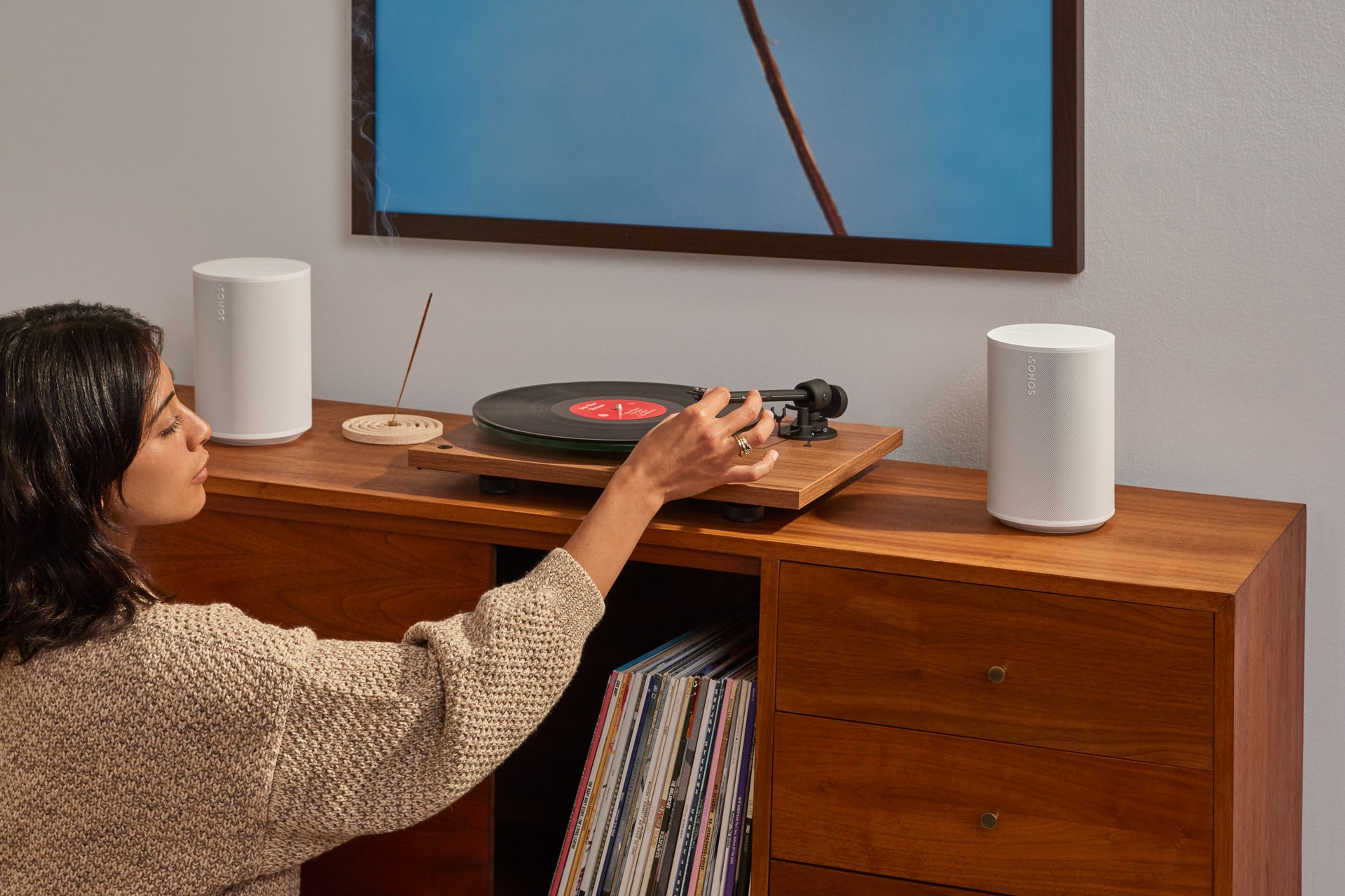 User listens to a vinyl record on a pair of white Sonos Era 100 SL speakers connected to their turntable