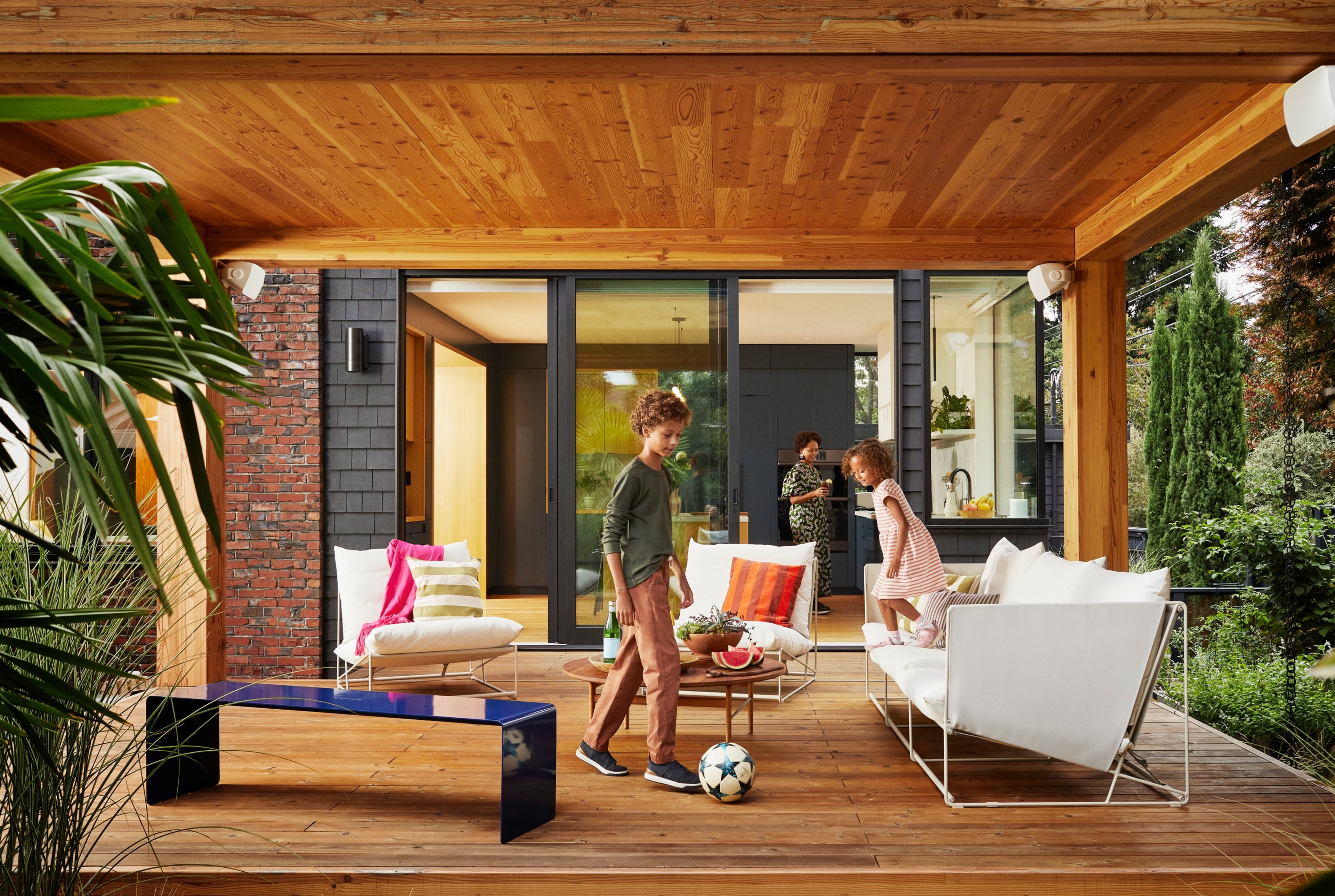 Eine Familie auf der Terrasse mit Outdoor Speakern von Sonos und Sonance