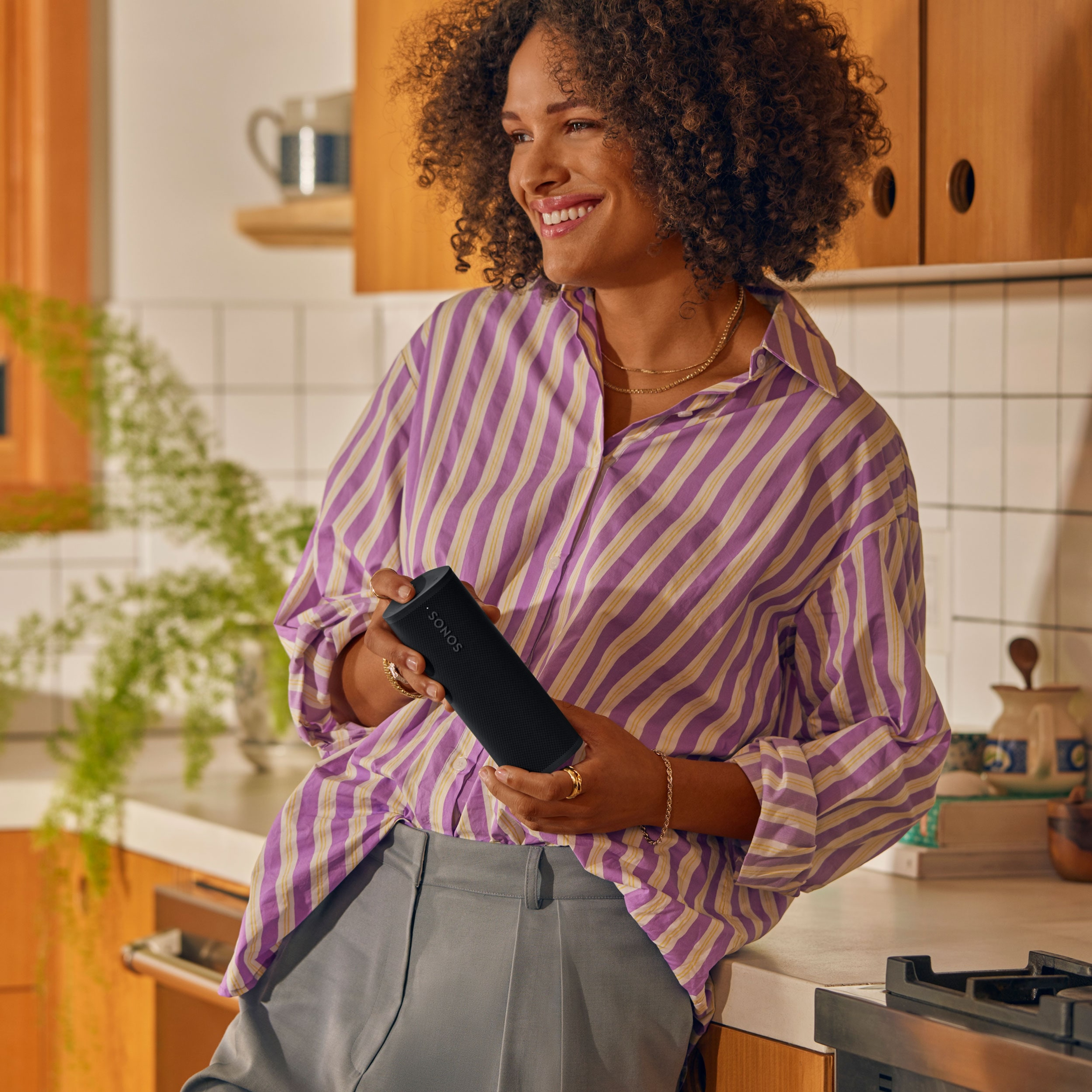 Eine Person mit einem Sonos Roam 2 in Schwarz in der Küche