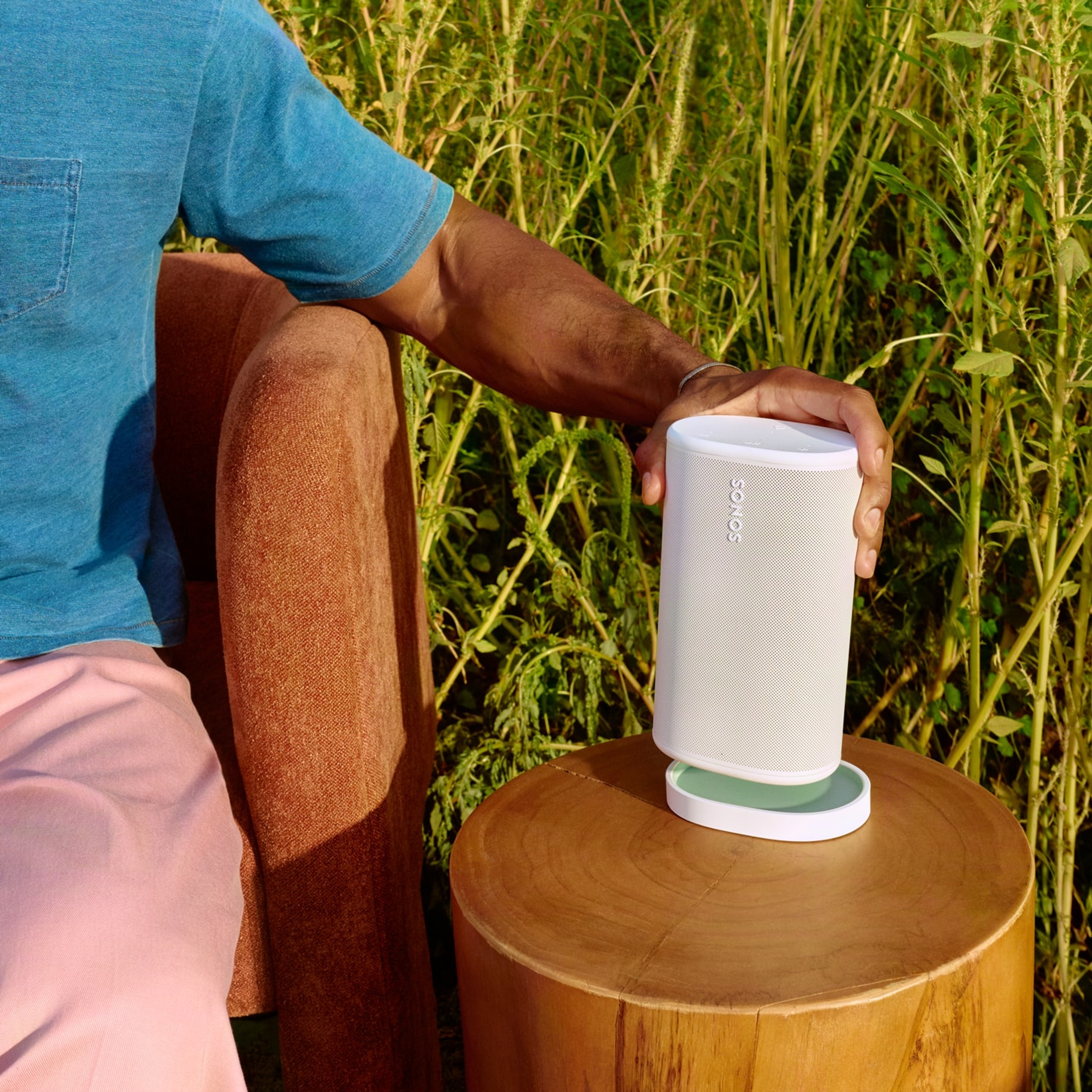 Utilisateur plaçant un Sonos Play blanc sur sa station de recharge assortie