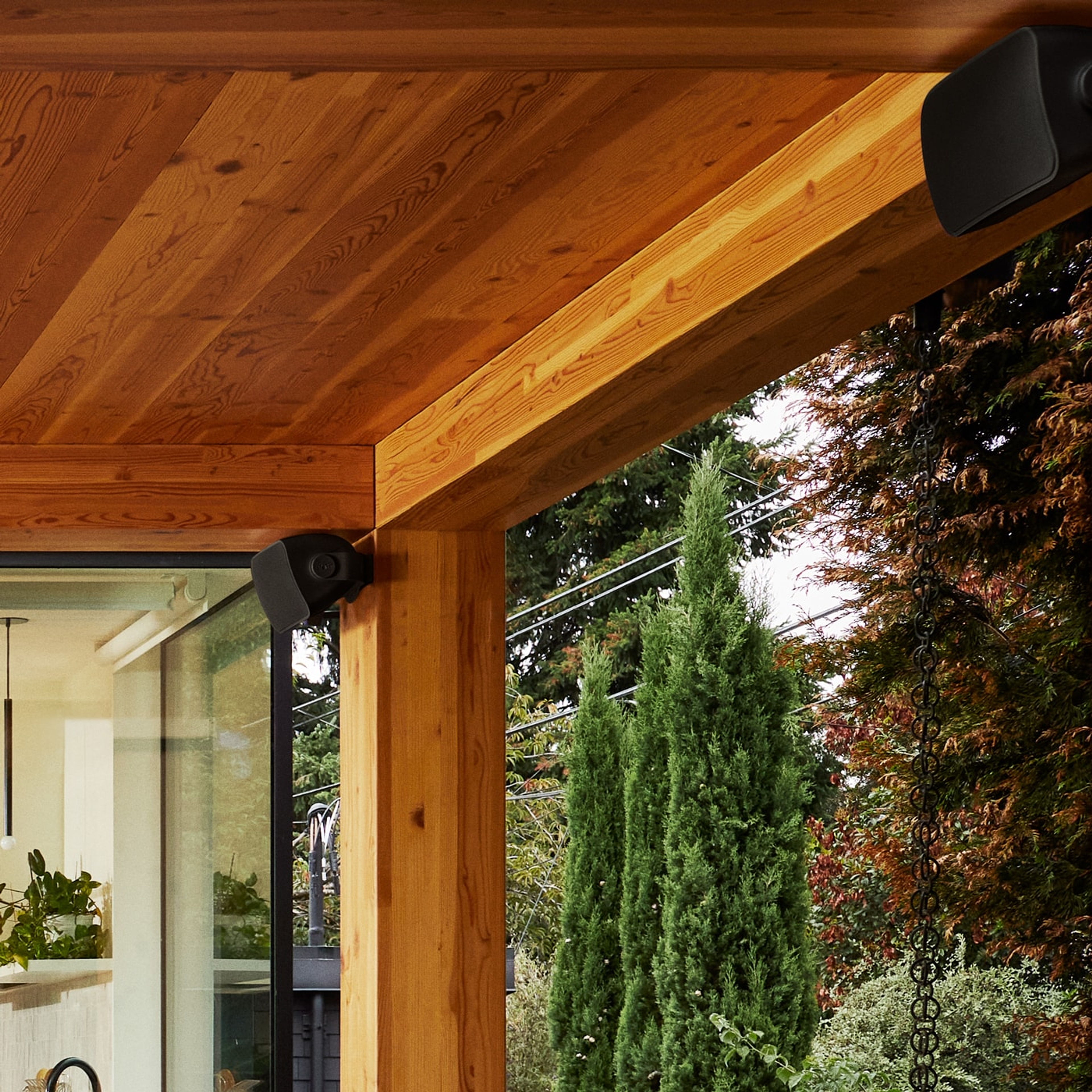 Nahaufnahme von unter dem Dachvorsprung einer Terrasse montierten Outdoor Speakern von Sonos und Sonance