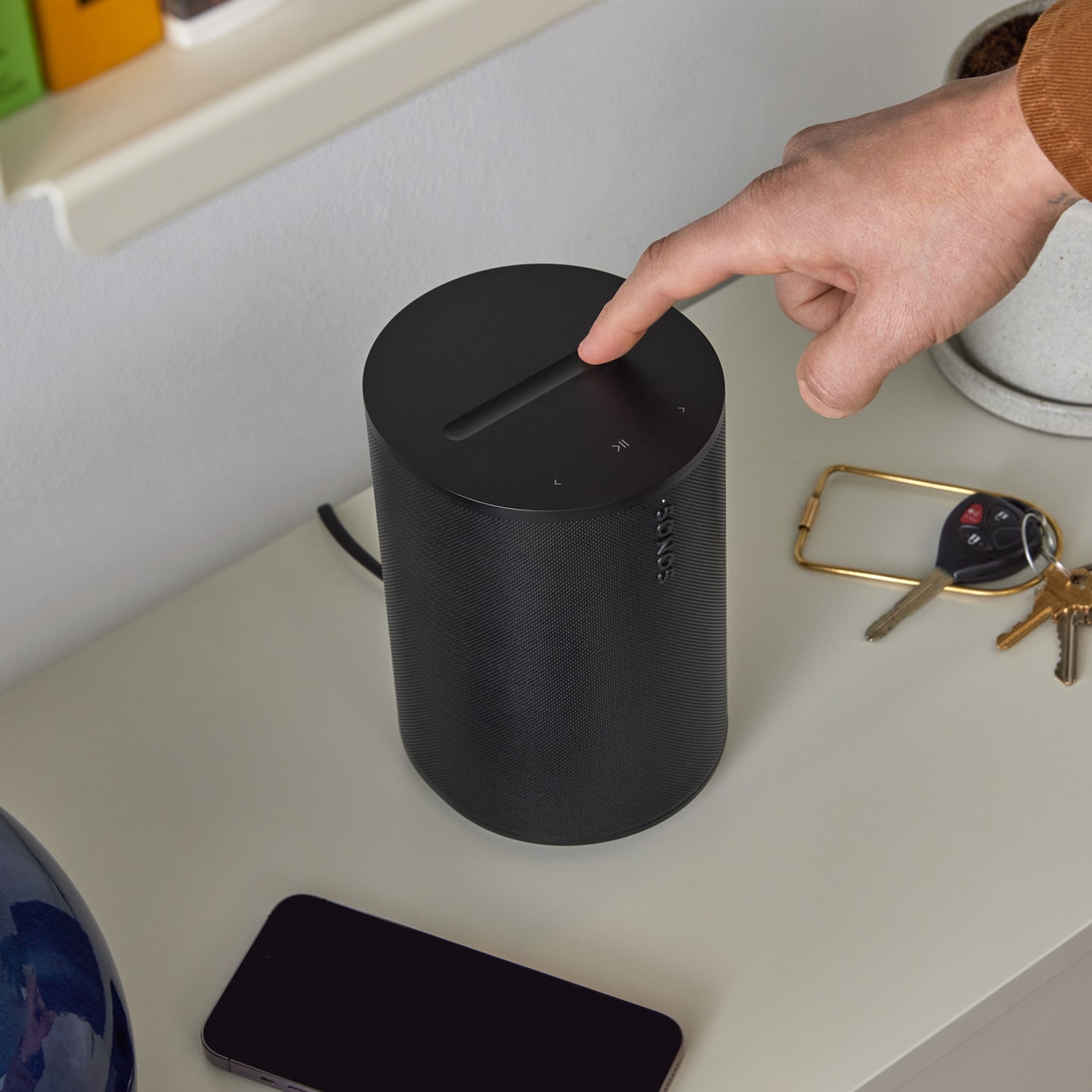 User adjusting music volume with the top touch controls on a black Era 100 SL