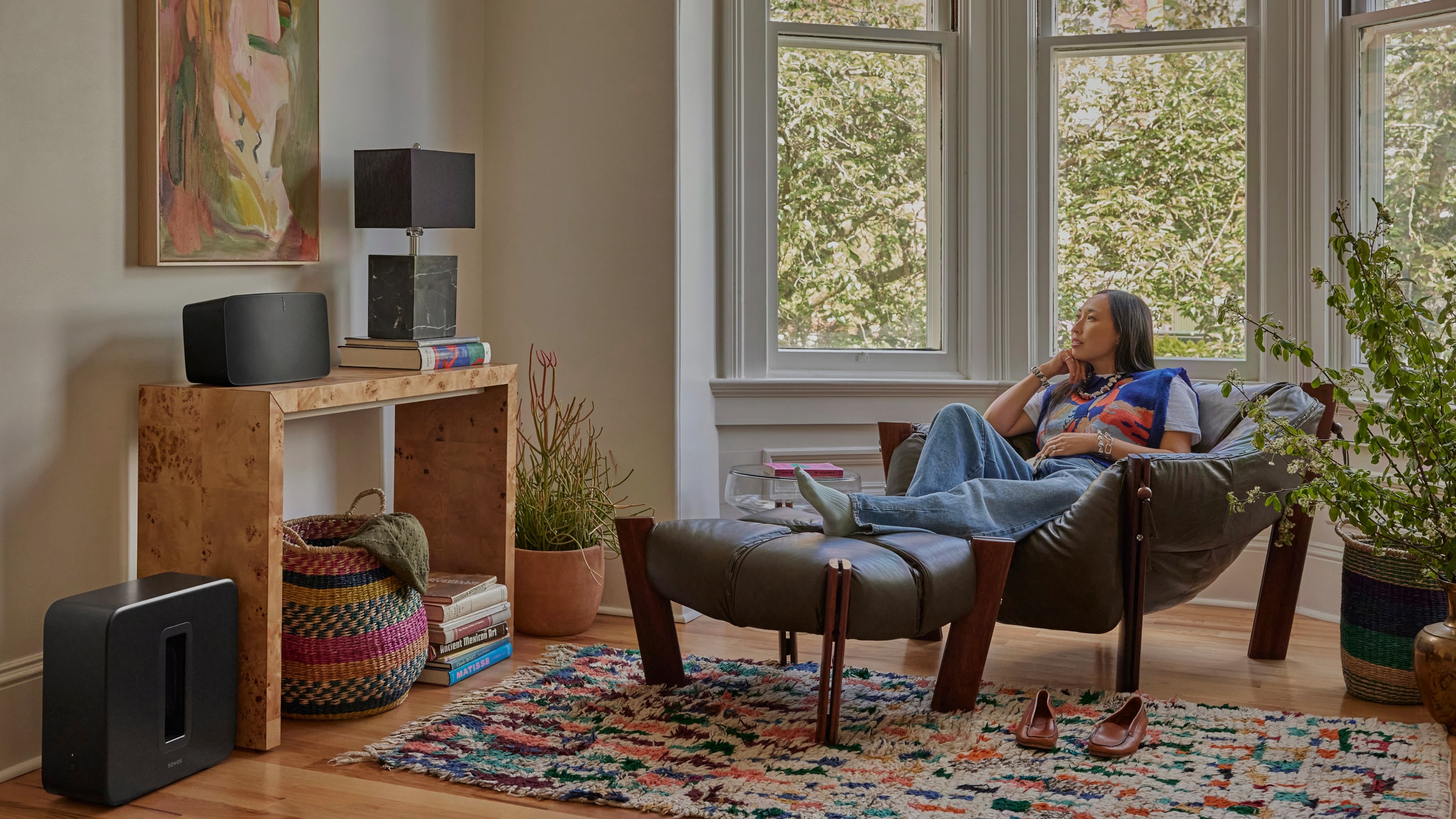 Person listening to Sonos Five and Sub 4 on a lounge chair