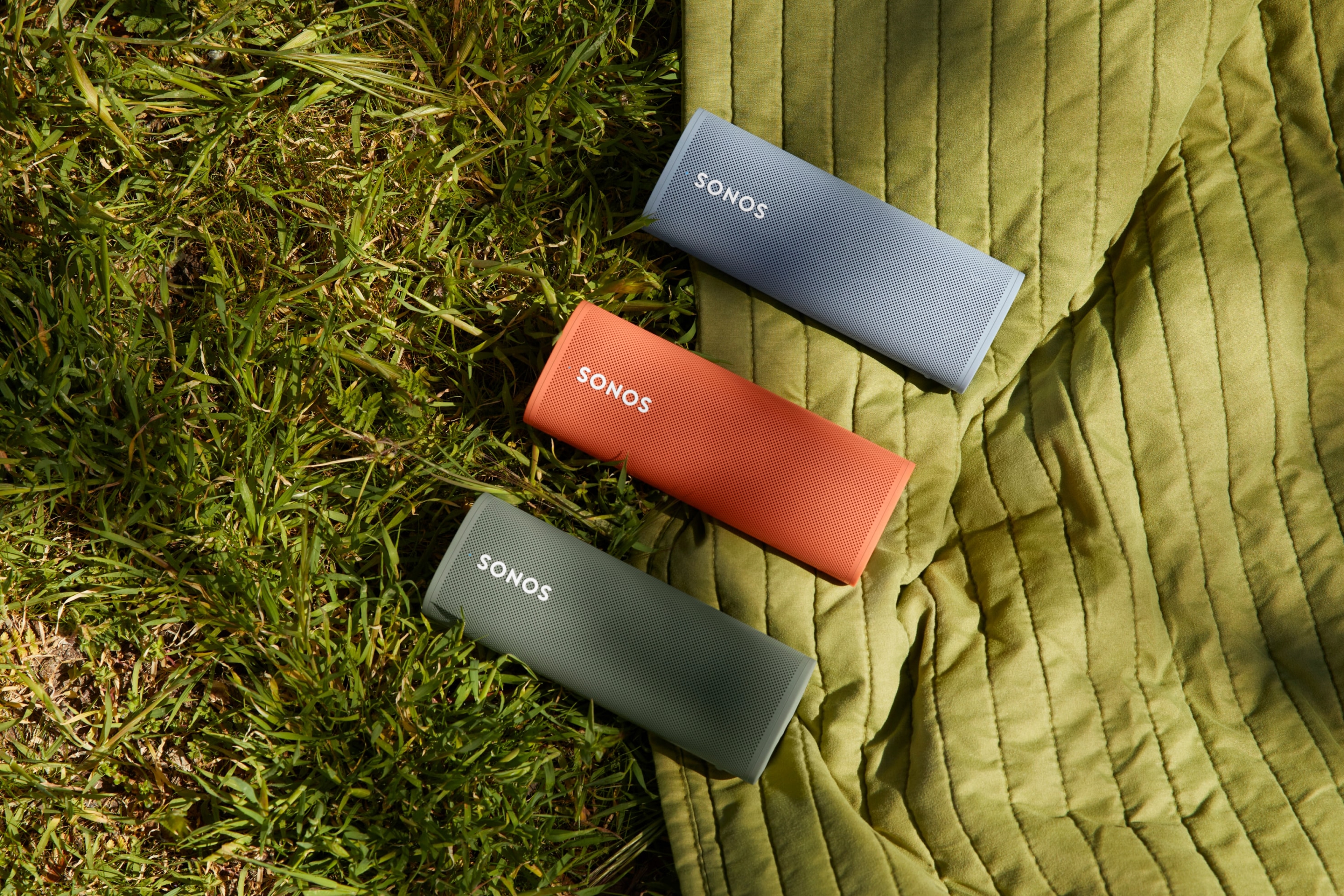 Bocinas Roam en colores Olive, Sunset y Wave sobre el pasto