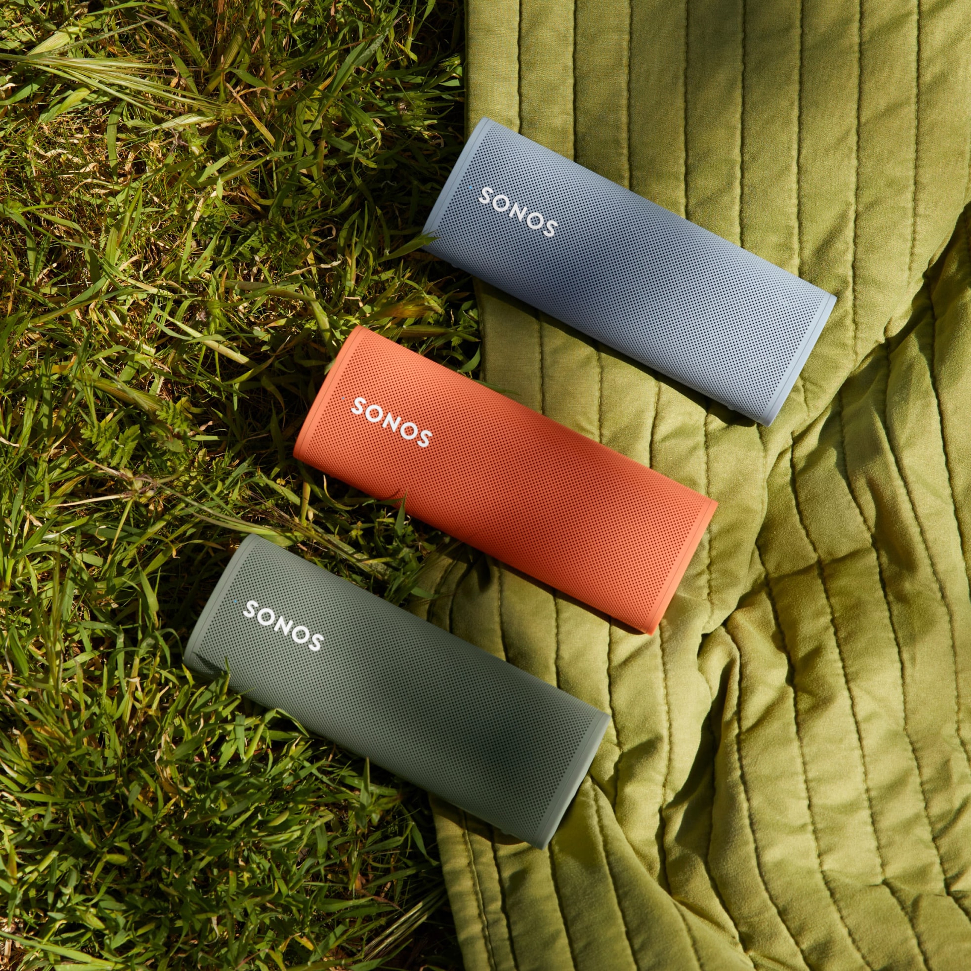 Bocinas Roam en colores Olive, Sunset y Wave sobre el pasto 