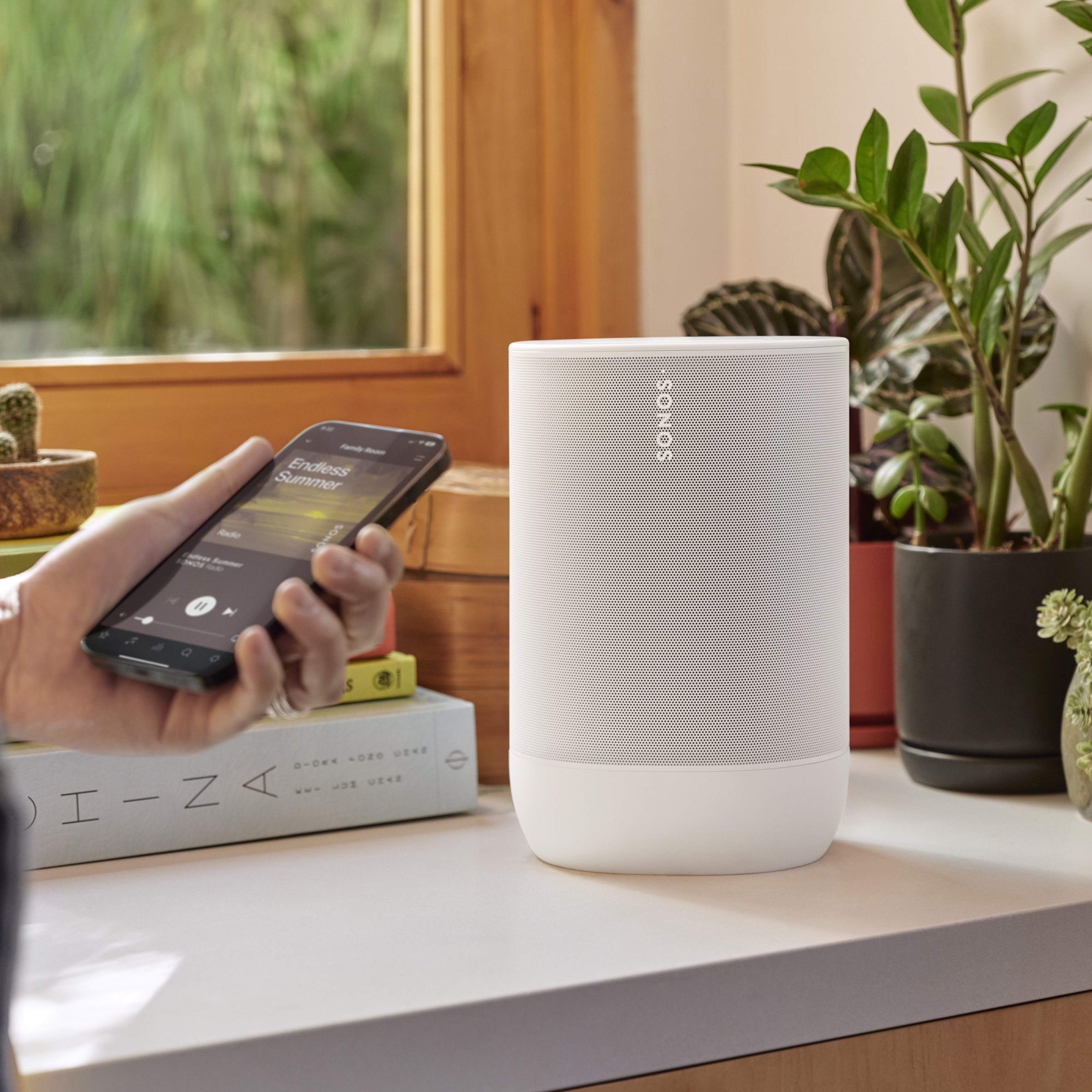 Osoba korzystająca z aplikacji Sonos do sterowania białym Move 2 za pomocą telefonu