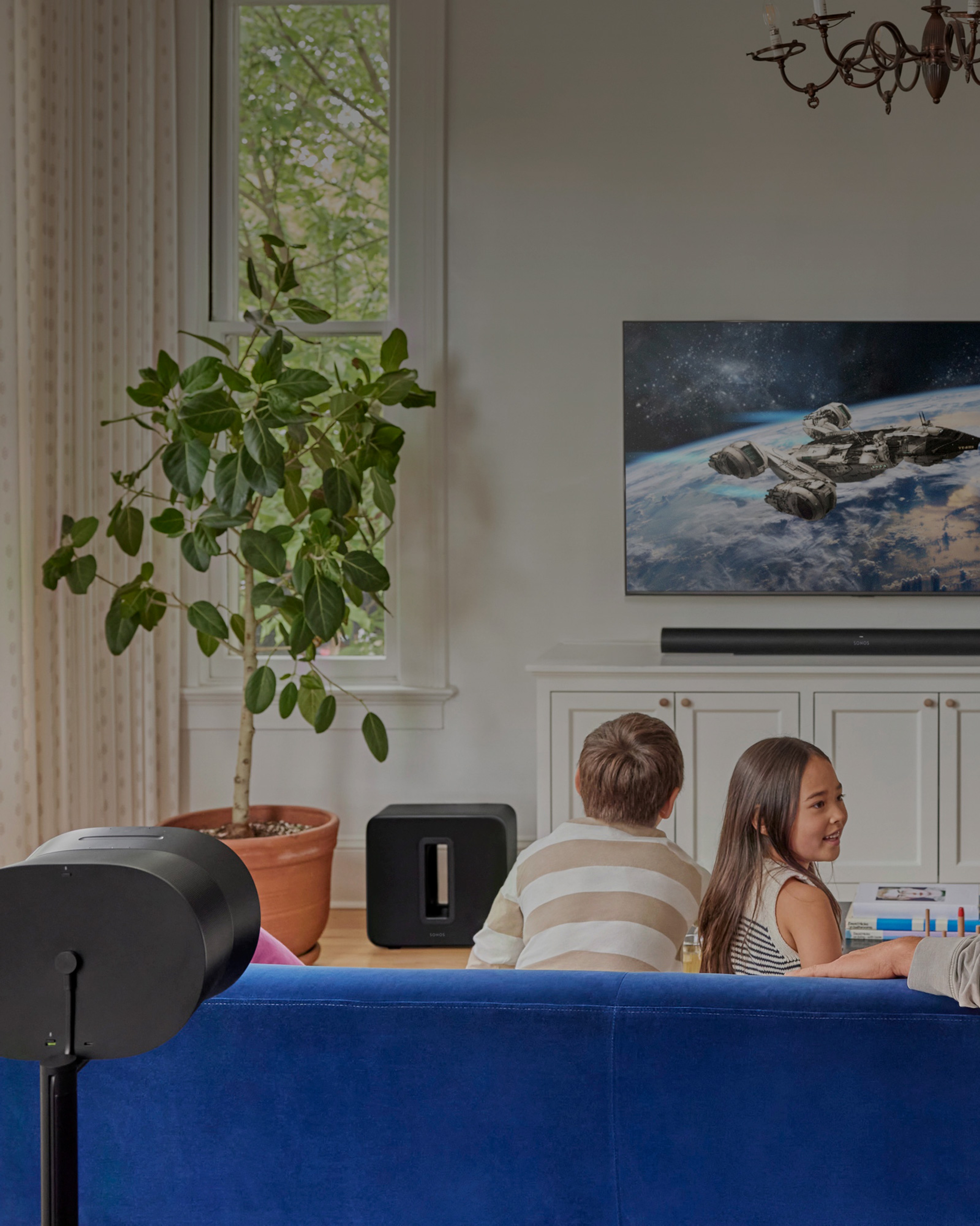 Una familia mira televisión en la sala con un set de teatro en casa con Sonos Arc Ultra, Sub 4 y Era 300