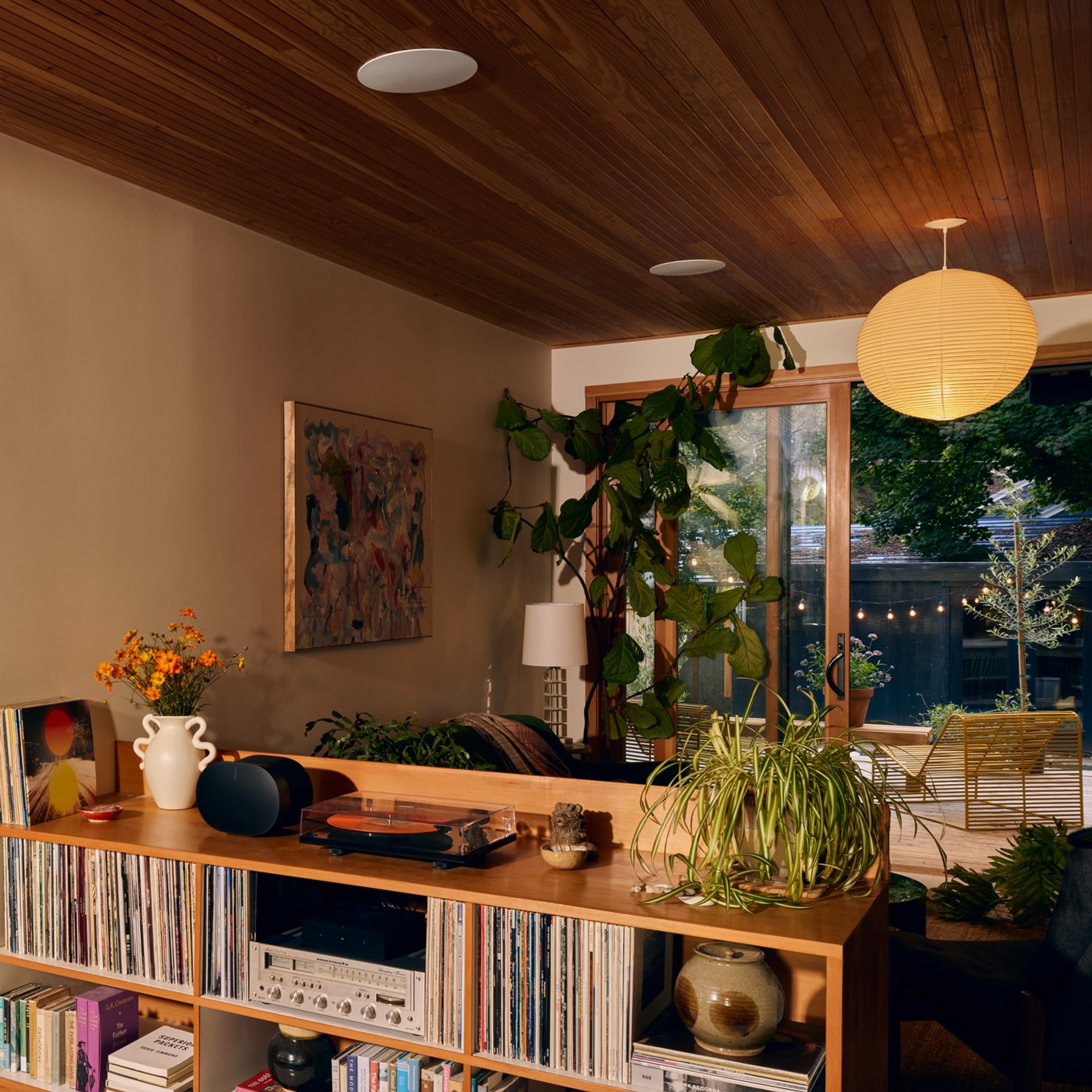 Altavoces In-Ceiling de Sonos y Sonance instalados en una sala de estar con un Era 300 y una librería