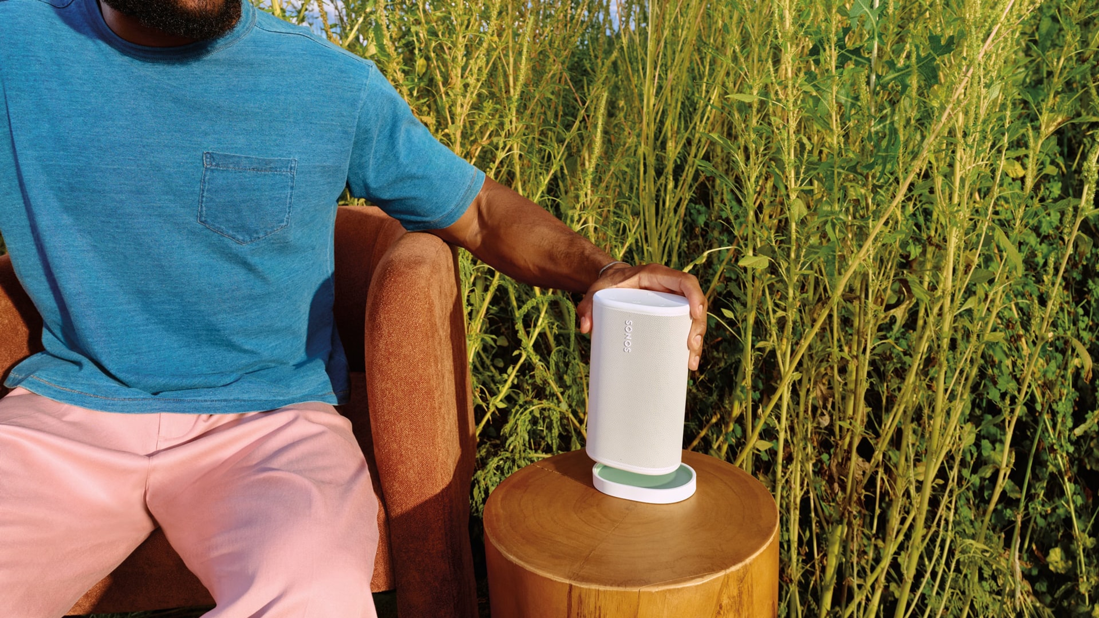 Utilisateur plaçant un Sonos Play blanc sur sa station de recharge assortie