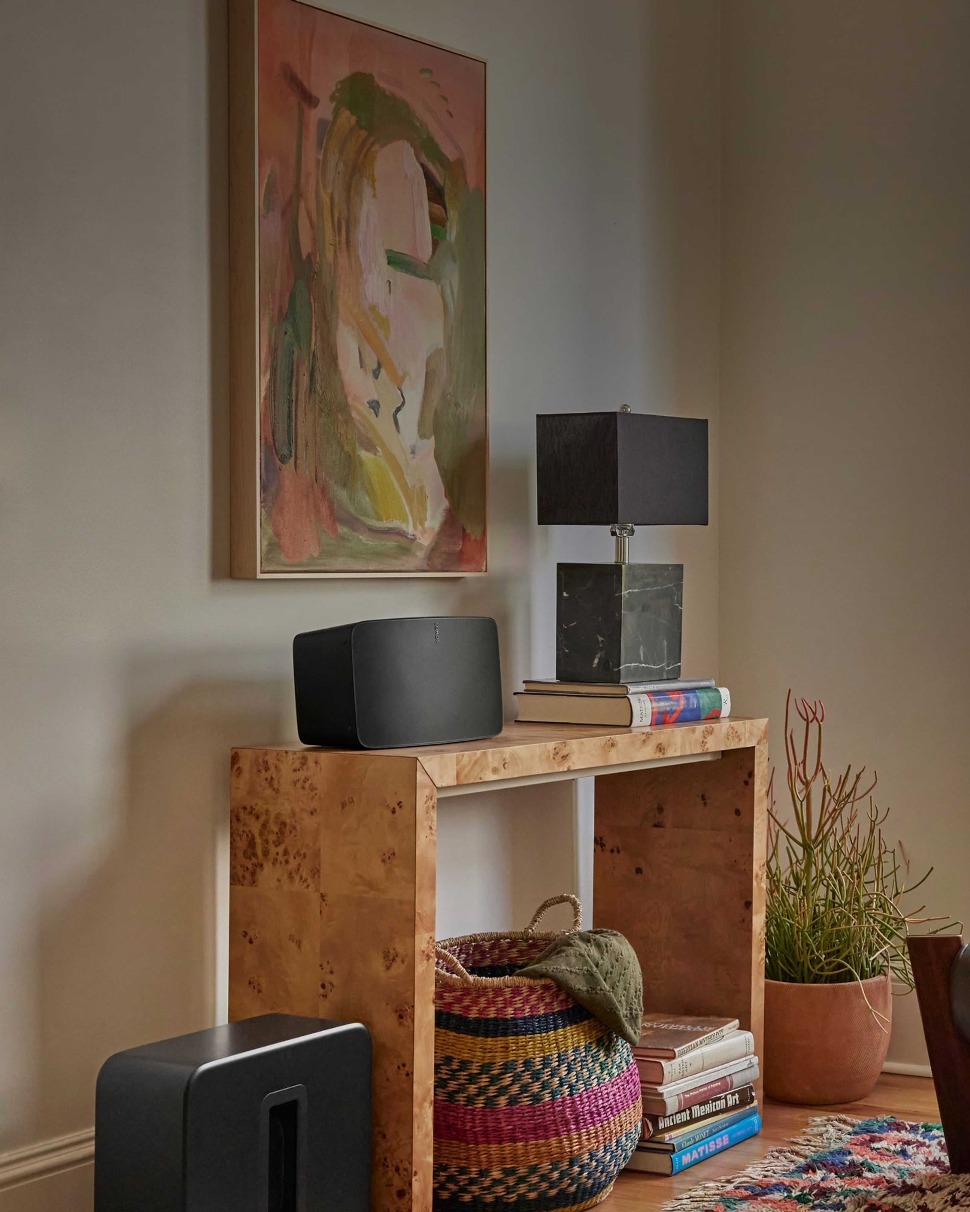 Sonos Five on top of a console table next to a lamp and a Sub 4 on the ground