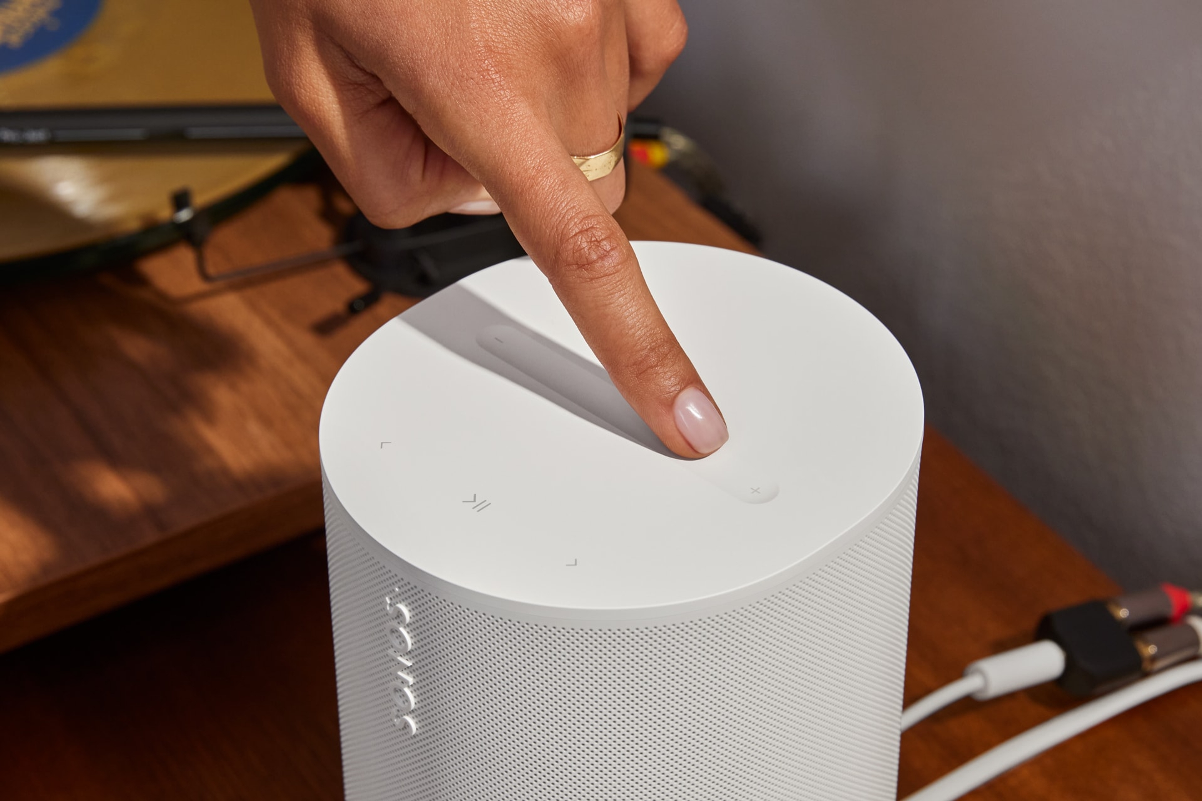 User adjusting music volume with the top touch controls on a white Era 100 SL
